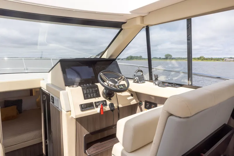 Slide: The Image of Interior helm of 2021 Regal 38 Grande Coupe yacht with modern controls and panoramic view. - 47