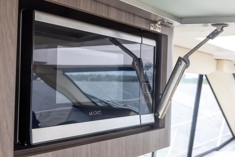Slide: The Image of Microwave in 2021 Regal 38 Grande Coupe yacht interior, with modern cabinetry and window view. - 49