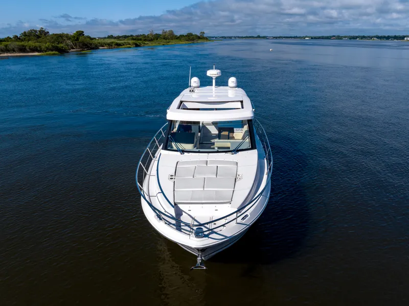 Slide: The Image of 2021 Regal 38 Grande Coupe yacht cruising on a serene river. - 8