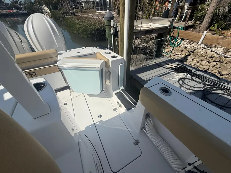 Slide: The Image of 2023 Sportsman Open 282 Center Console boat docked, featuring seating and storage areas. - 17