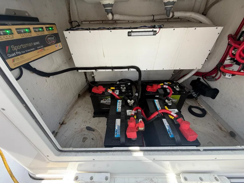 Slide: The Image of 2023 Sportsman Open 282 Center Console battery compartment with wiring and charger. - 29