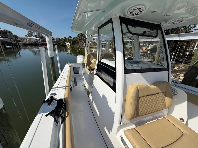 Slide: The Image of 2023 Sportsman Open 282 Center Console boat docked by calm waters. - 44