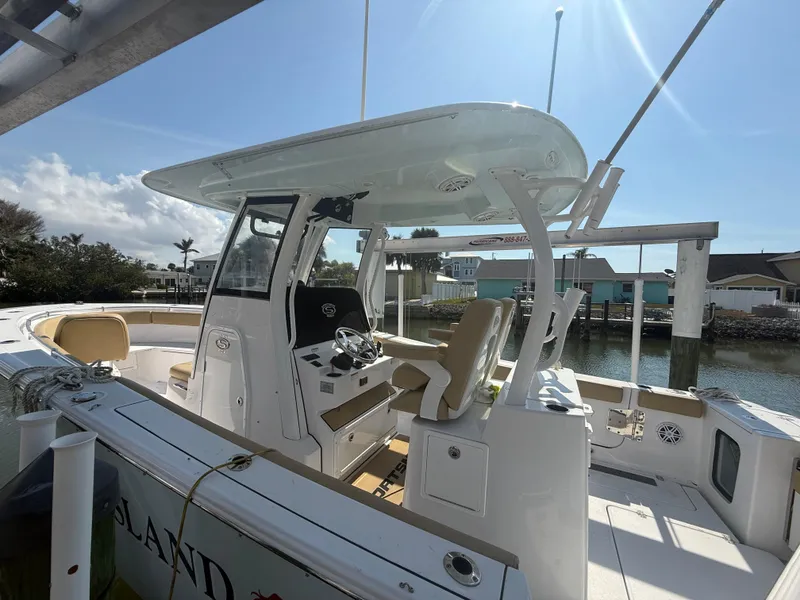 Slide: The Image of 2023 Sportsman Open 282 Center Console boat docked under sunny skies. - 4