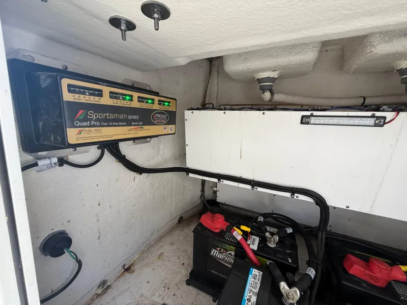 Slide: The Image of 2023 Sportsman Open 282 Center Console battery compartment with charger and wiring. - 27