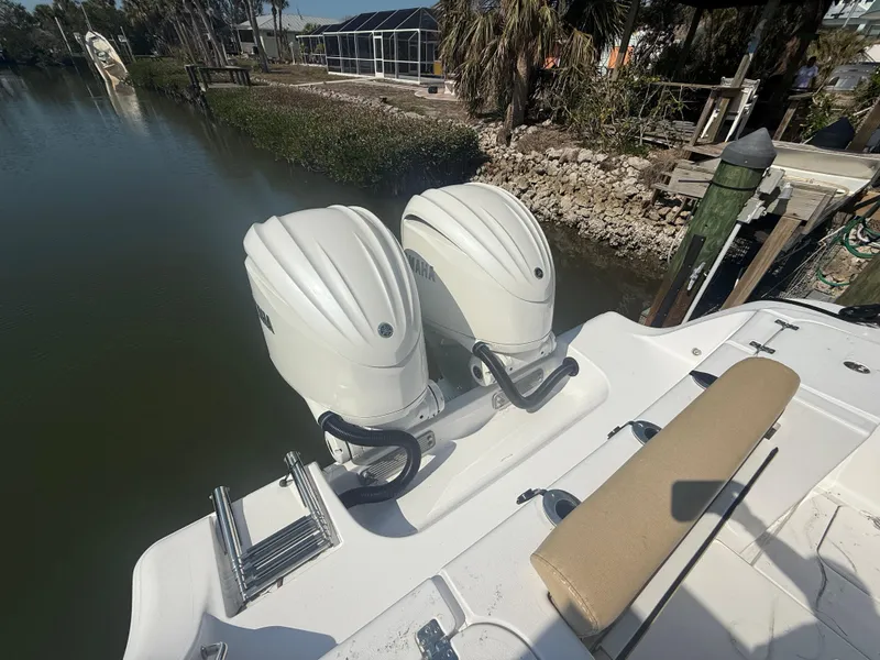 Slide: The Image of 2023 Sportsman Open 282 Center Console with dual outboard engines docked by water. - 22