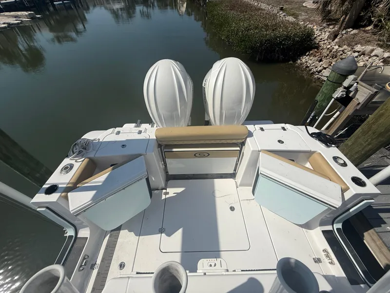 Slide: The Image of 2023 Sportsman Open 282 Center Console boat with dual engines docked by the water. - 8