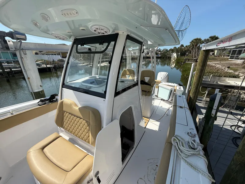 Slide: The Image of 2023 Sportsman Open 282 Center Console boat docked, featuring tan seating and modern design. - 43