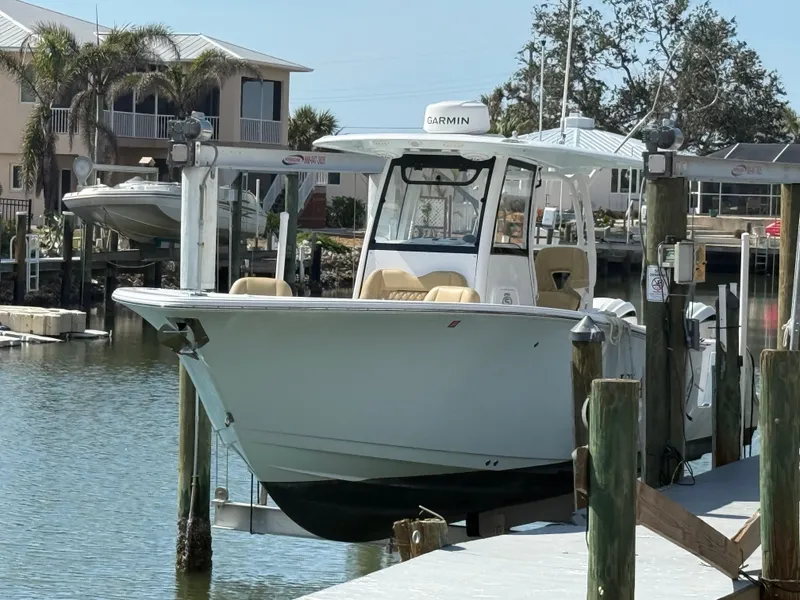 Slide: The Image of 2023 Sportsman Open 282 Center Console boat docked in a marina. - 2