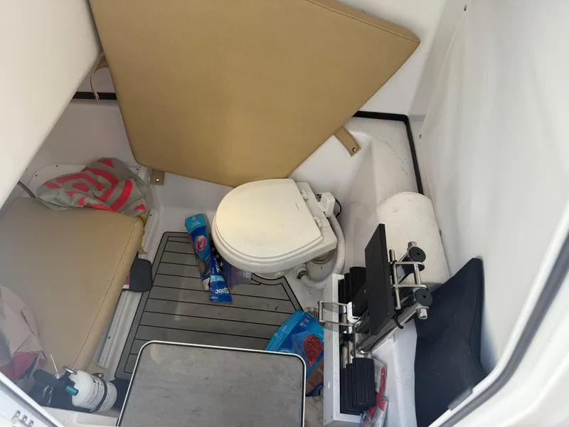 Slide: The Image of 2023 Sportsman Open 282 Center Console boat interior with toilet and storage area. - 26