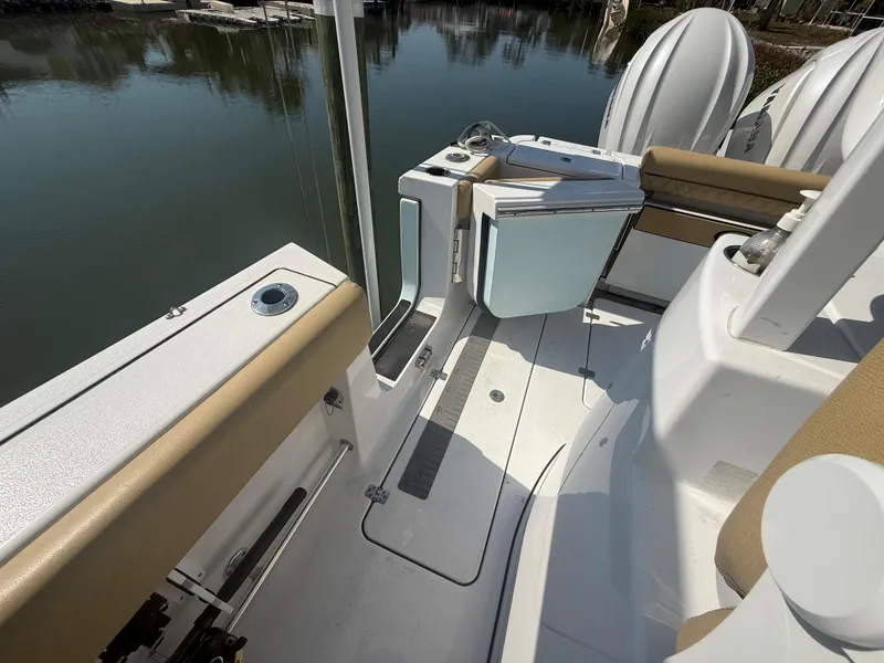 Slide: The Image of 2023 Sportsman Open 282 Center Console boat interior with seating and open door. - 16