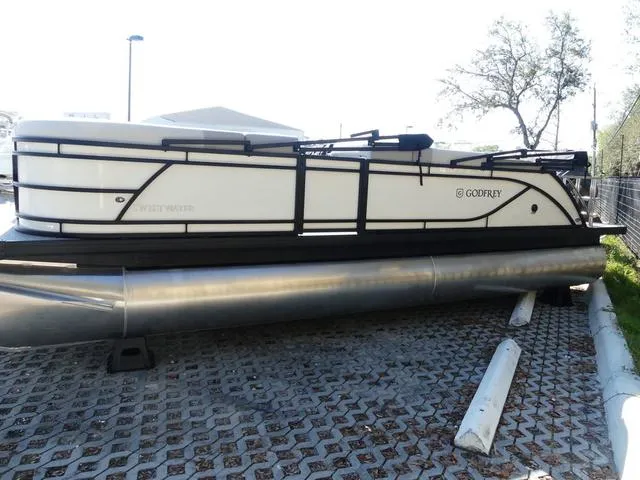 Slide: The Image of 2025 Godfrey Pontoons Sweetwater 2286 SFL pontoon boat parked on a paved surface. - 4