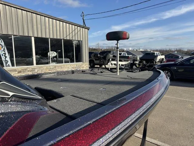 Slide: The Image of 2018 Skeeter FX21 LE boat with a spacious deck, parked outside a showroom. - 8