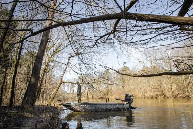 Slide: The Image of 2025 Edge Duck Boats HPSD 756DB navigating a serene river surrounded by trees. - 11