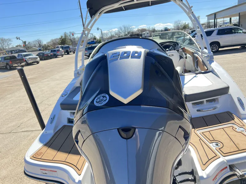 Slide: The Image of 2023 Chaparral 21SSi OB SPORT boat with powerful outboard engine, parked outdoors. - 14