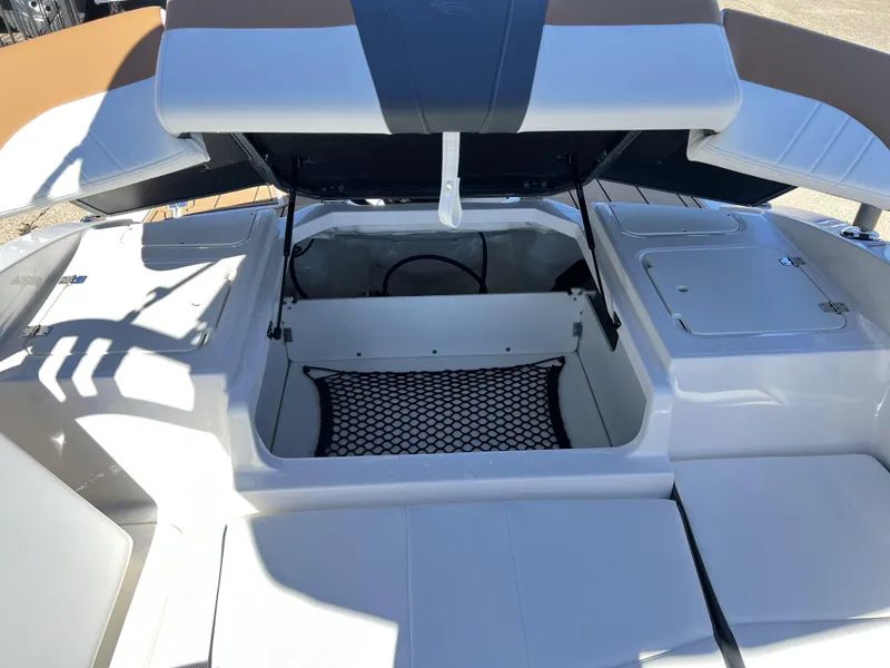 Slide: The Image of 2023 Chaparral 21SSi OB SPORT boat storage compartment with open hatch and netting. - 9