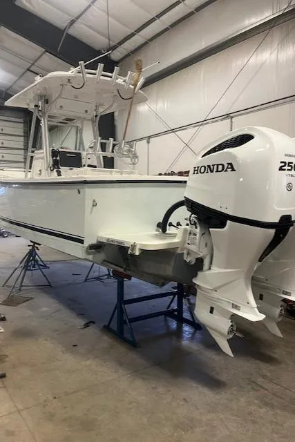 Slide: The Image of 2003 Regulator 26 Forward Seating boat with Honda 250 outboard in a garage. - 10