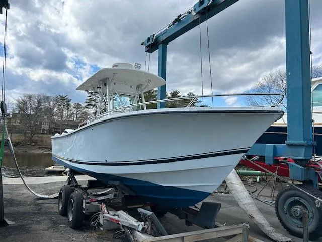 Slide: The Image of 2003 Regulator 26 Forward Seating boat on trailer under cloudy sky. - 11