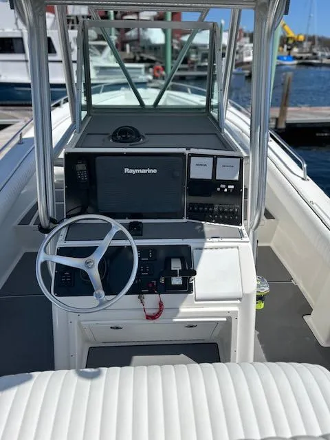 Slide: The Image of 2003 Regulator 26 Forward Seating boat with Raymarine navigation, docked at marina. - 12