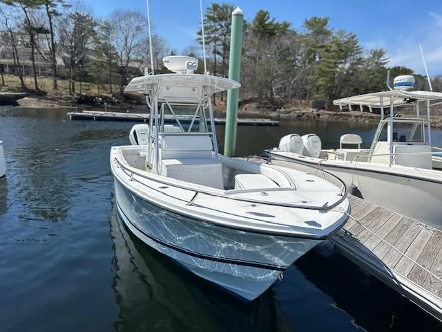 Slide: The Image of 2003 Regulator 26 Forward Seating boat docked in a serene marina setting. - 14