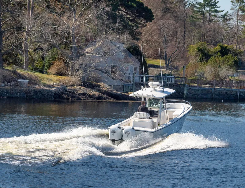 Slide: The Image of 2003 Regulator 26 Forward Seating boat cruising on a scenic river. - 17