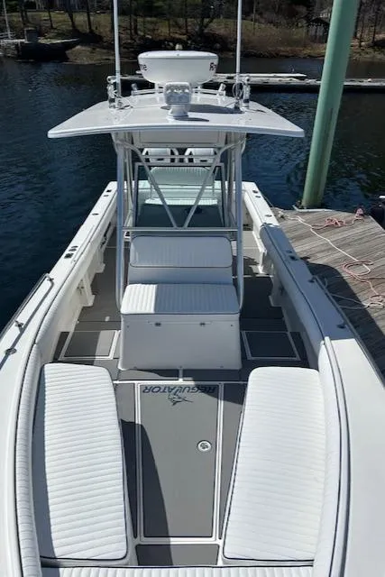 Slide: The Image of 2003 Regulator 26 Forward Seating boat docked, showcasing spacious deck and seating. - 19