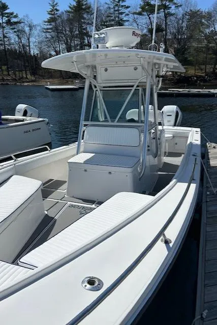 Slide: The Image of 2003 Regulator 26 Forward Seating boat docked by a serene lake. - 20