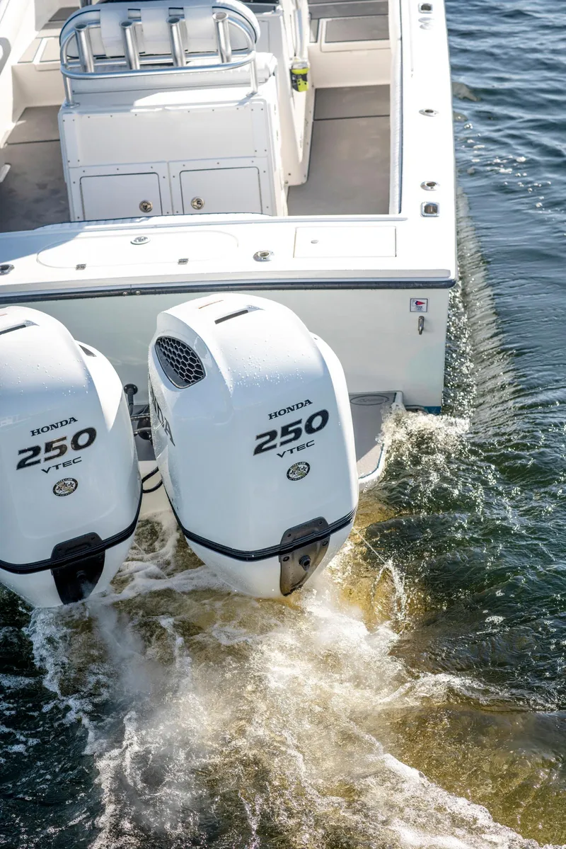 Slide: The Image of 2003 Regulator 26 Forward Seating boat with twin Honda 250 engines on water. - 27