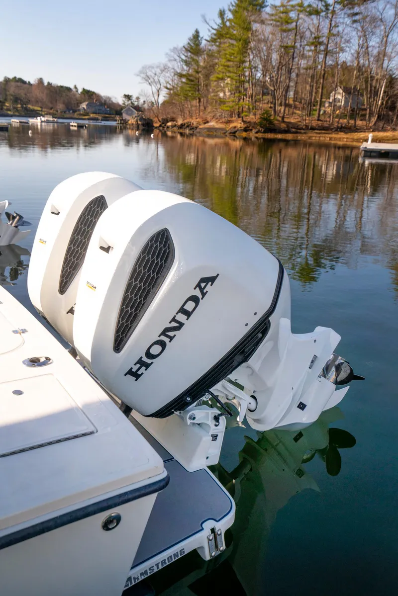 Slide: The Image of 2003 Regulator 26 Forward Seating boat with twin Honda outboard engines on a calm lake. - 28