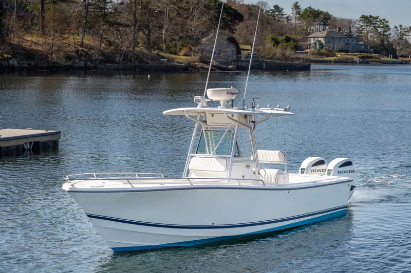 Slide: The Image of 2003 Regulator 26 Forward Seating boat cruising on a calm lake. - 30
