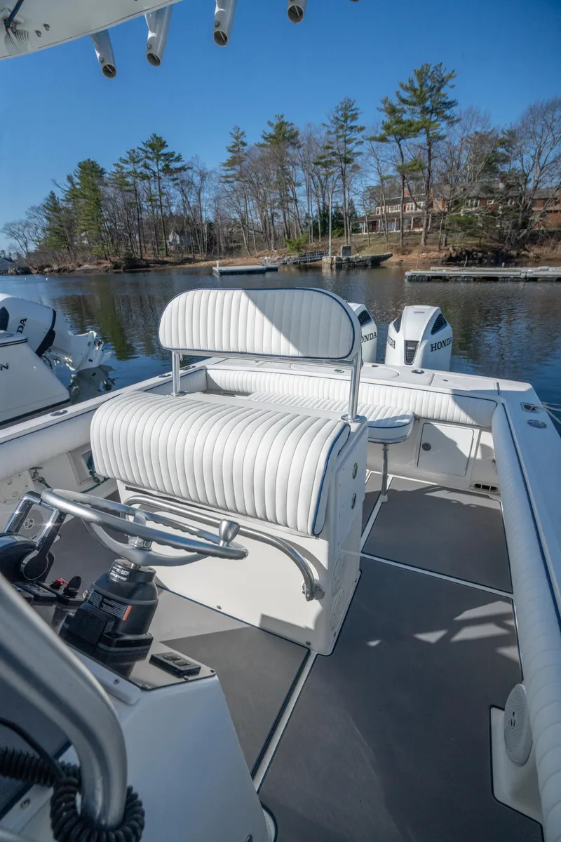 Slide: The Image of 2003 Regulator 26 Forward Seating boat with white interior on a calm lake. - 31