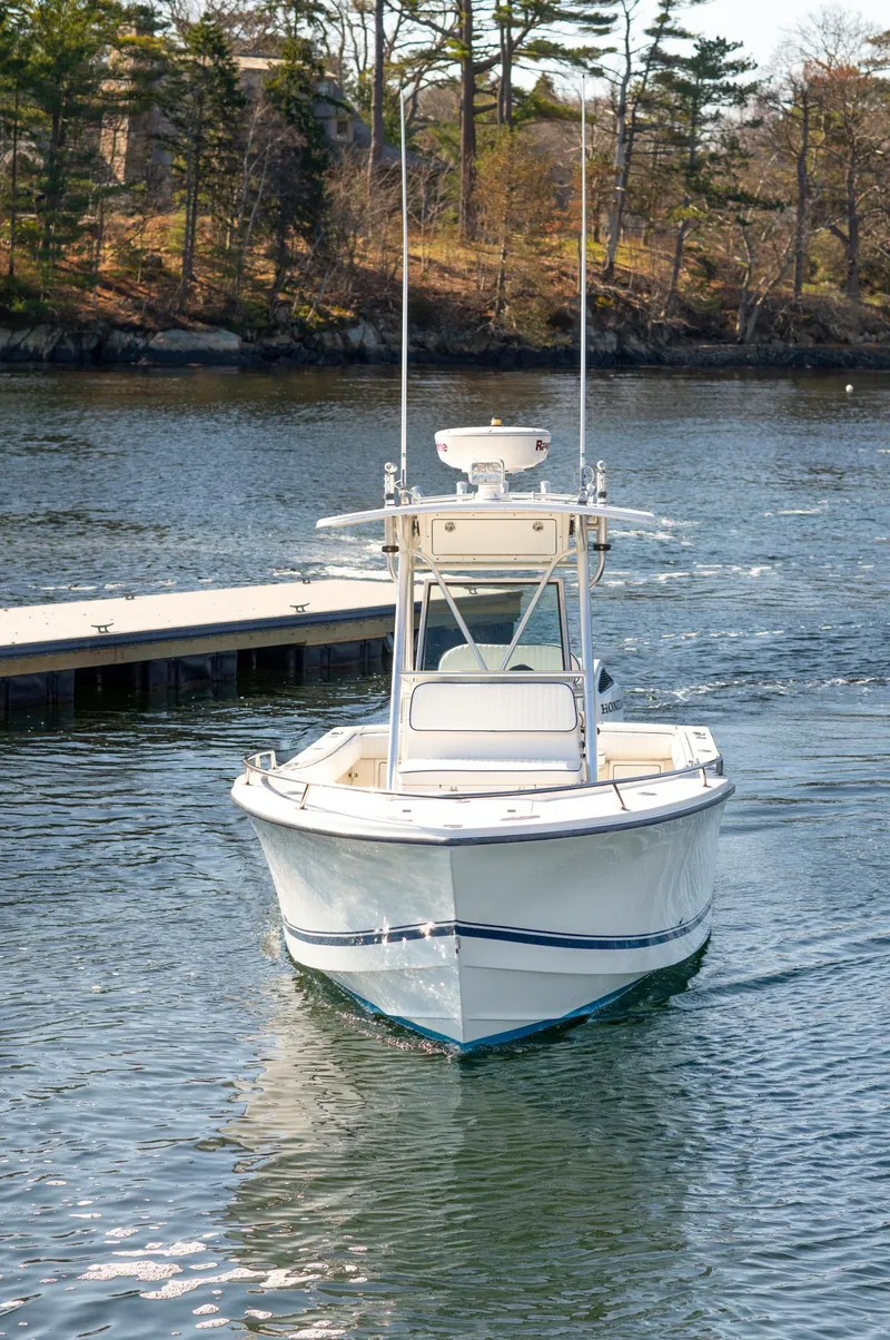 Slide: The Image of 2003 Regulator 26 Forward Seating boat on calm water near dock. - 32