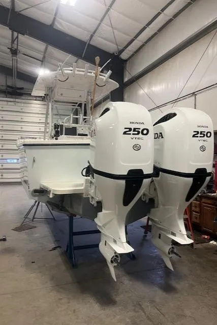 Slide: The Image of 2003 Regulator 26 Forward Seating boat with twin Honda 250 VTEC engines in a garage. - 4