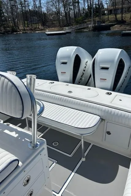 Slide: The Image of 2003 Regulator 26 Forward Seating boat with dual Honda outboard engines on a calm lake. - 6
