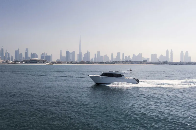 Slide: The Image of SilverCAT 40LUX boat cruising with city skyline backdrop, 2026 model. - 7