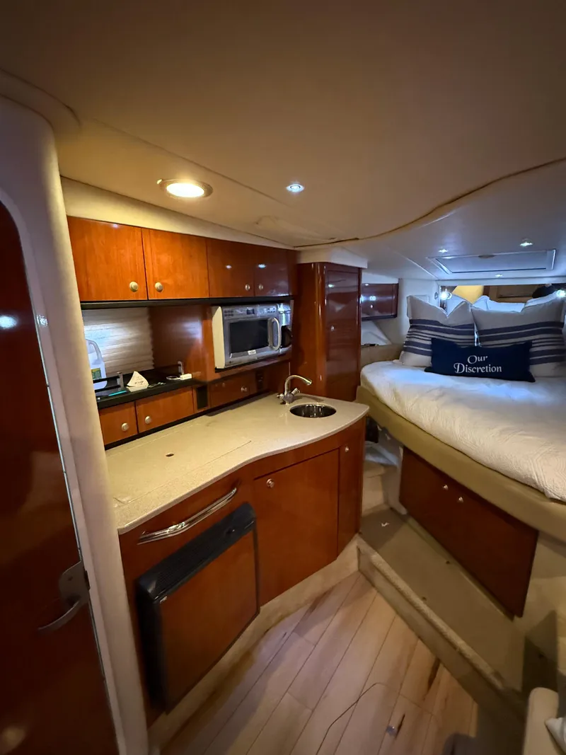 Slide: The Image of 2007 Sea Ray 310 Sundancer cabin interior with kitchenette and cozy sleeping area. - 18