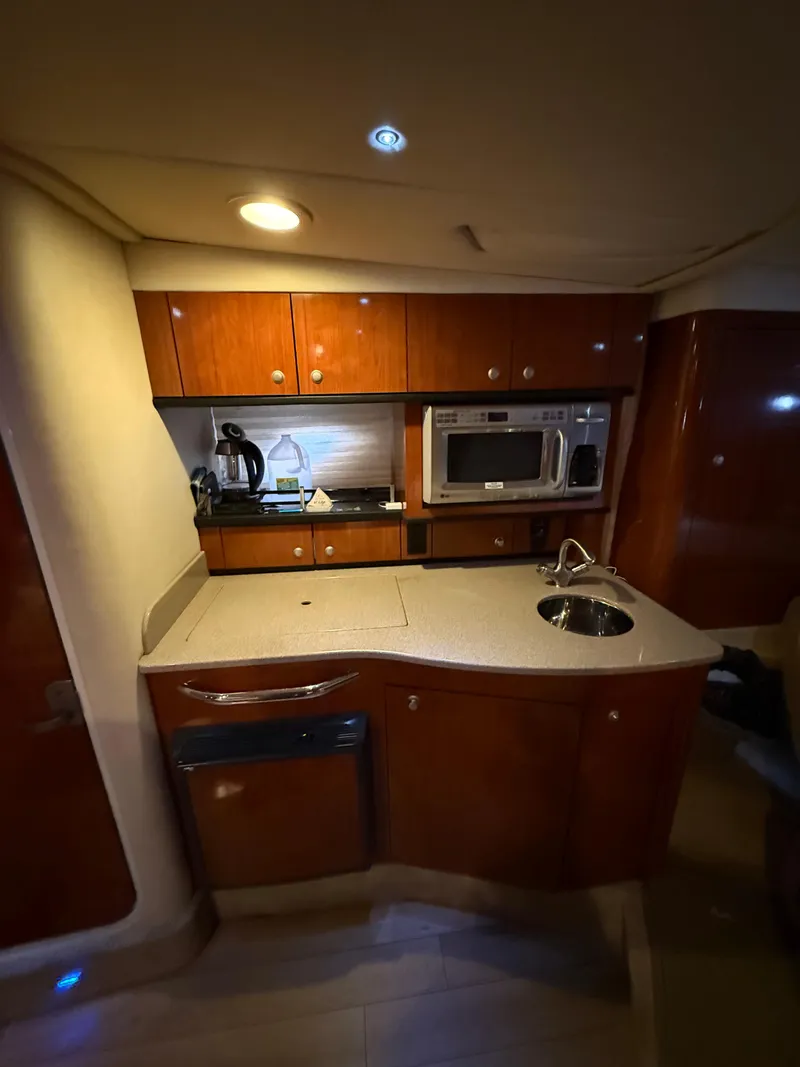 Slide: The Image of 2007 Sea Ray 310 Sundancer interior kitchen with wood cabinets and modern appliances. - 22