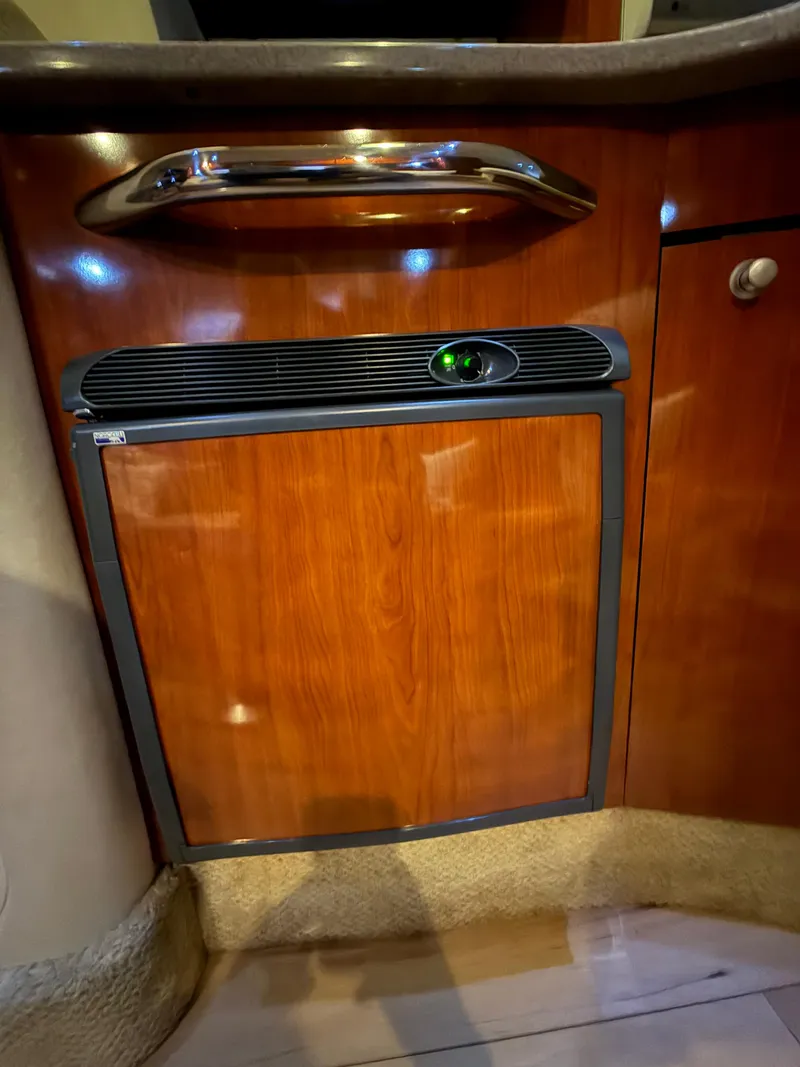 Slide: The Image of 2007 Sea Ray 310 Sundancer interior with wood finish cabinetry and built-in appliance. - 23