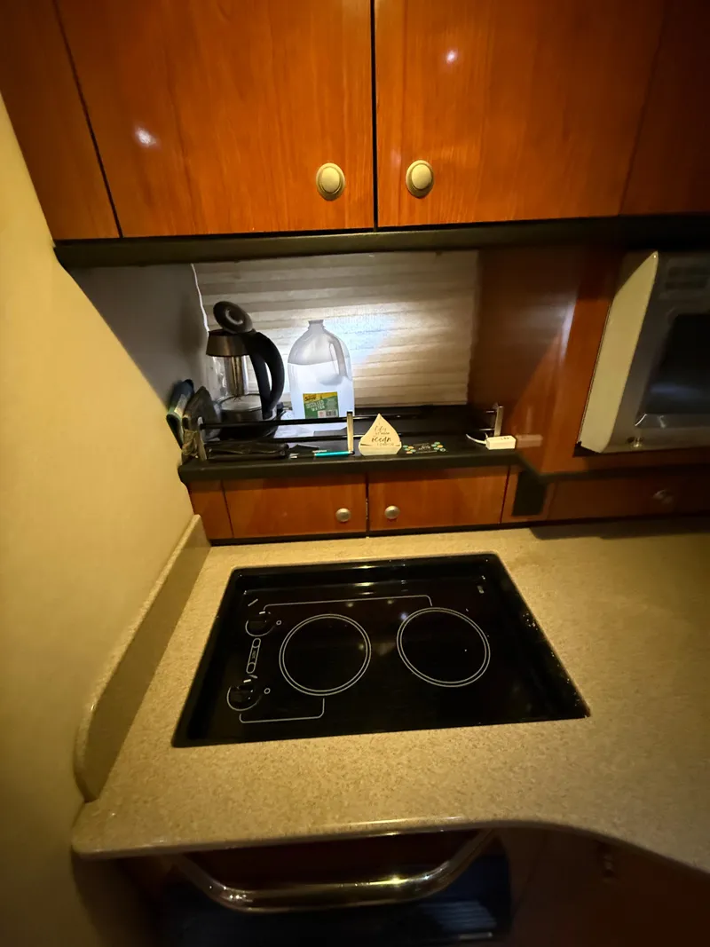 Slide: The Image of 2007 Sea Ray 310 Sundancer kitchen with stove, cabinets, and appliances. - 25