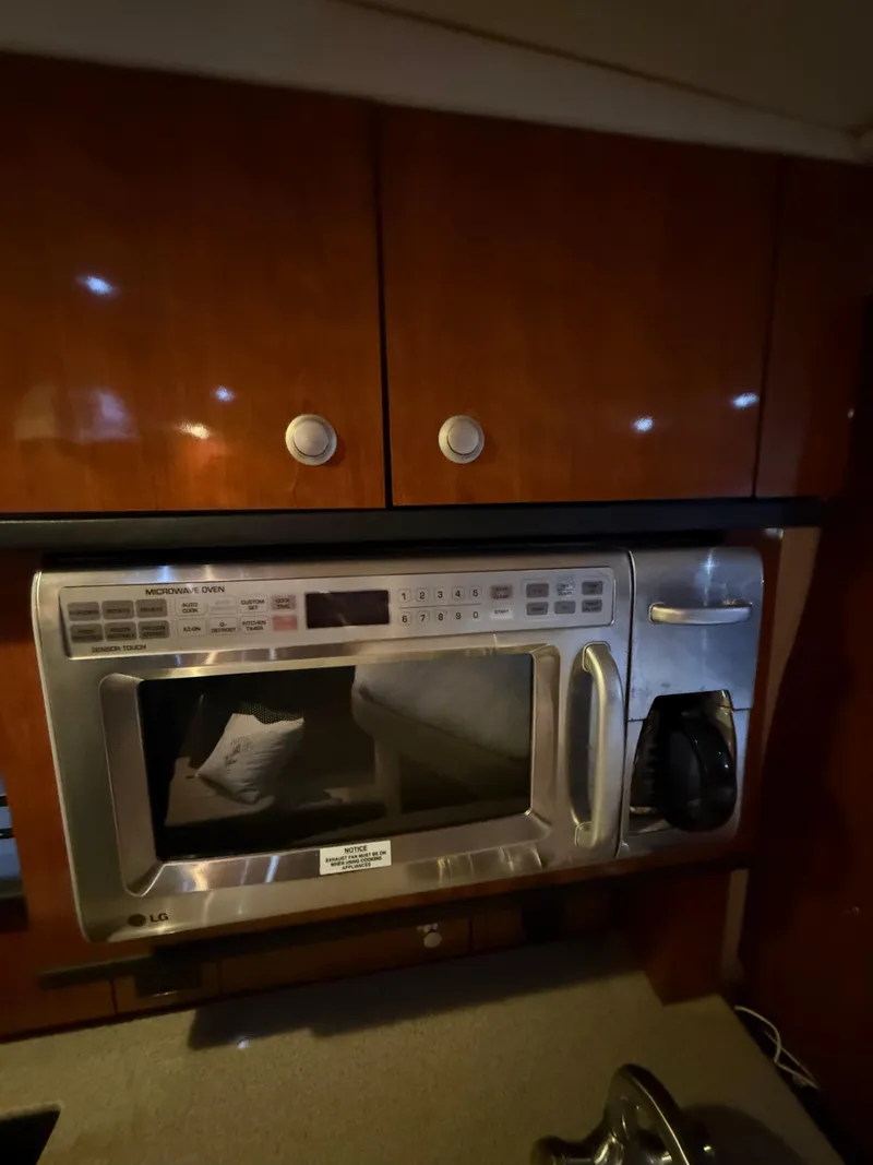 Slide: The Image of Microwave in 2007 Sea Ray 310 Sundancer yacht kitchen, with wooden cabinets above. - 26