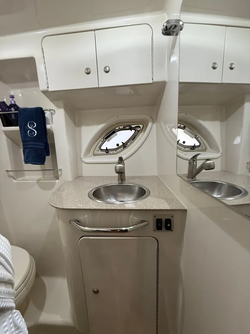 Slide: The Image of 2007 Sea Ray 310 Sundancer bathroom with sink, mirror, and storage cabinets. - 27