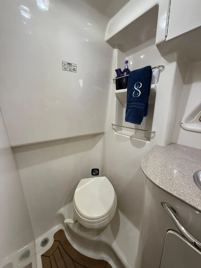 Slide: The Image of 2007 Sea Ray 310 Sundancer bathroom with toilet, sink, and storage shelves. - 28