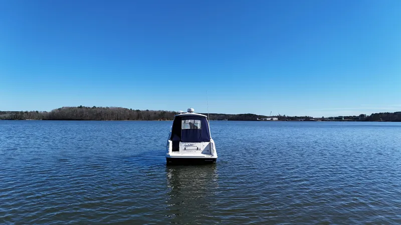 Slide: The Image of 2007 Sea Ray 310 Sundancer boat on calm lake under clear blue sky. - 5