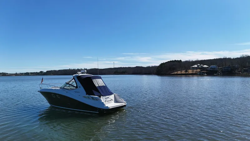 Slide: The Image of 2007 Sea Ray 310 Sundancer boat on calm lake under clear blue sky. - 6