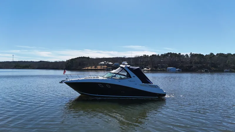 Slide: The Image of 2007 Sea Ray 310 Sundancer boat on a calm lake under clear skies. - 7
