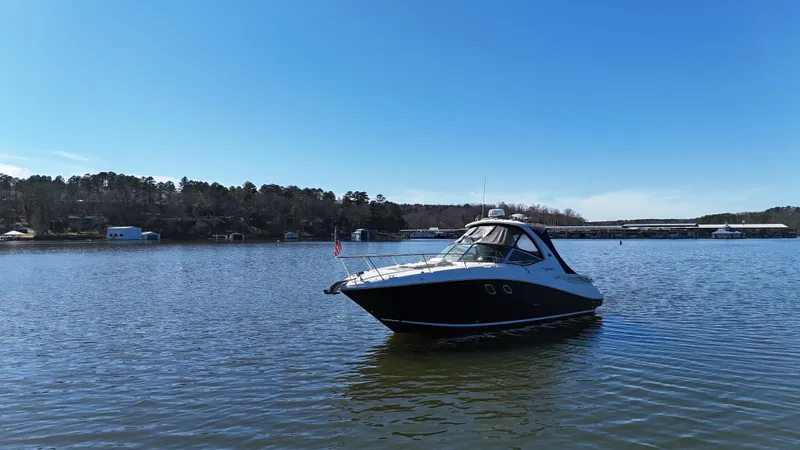 Slide: The Image of 2007 Sea Ray 310 Sundancer yacht on calm lake under clear blue sky. - 8