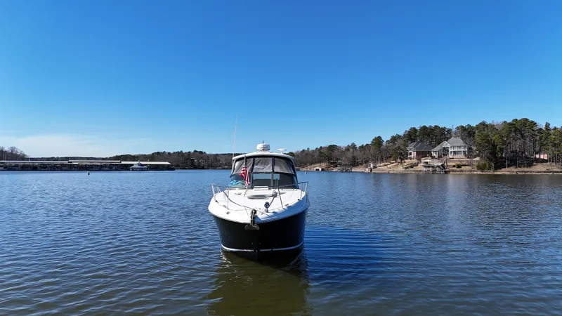 Slide: The Image of 2007 Sea Ray 310 Sundancer boat on a calm lake under clear blue skies. - 9