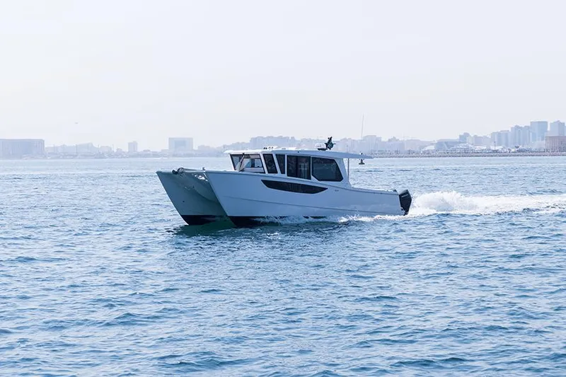 Slide: The Image of 2026 SilverCAT 46WA boat cruising on open water near a city skyline. - 1