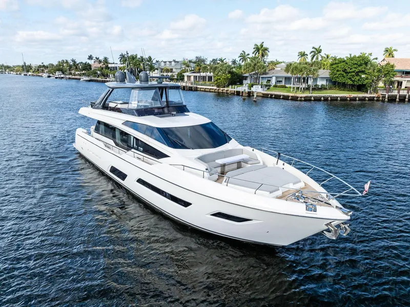 Slide: The Image of 2019 Ferretti Yachts 780 cruising on a scenic waterway with luxury homes in the background. - 5