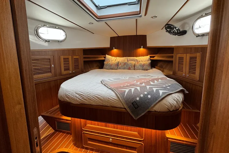 Slide: The Image of Luxurious cabin interior of 2026 Helmsman Trawlers 38 Sedan with wood finish and cozy bedding. - 13