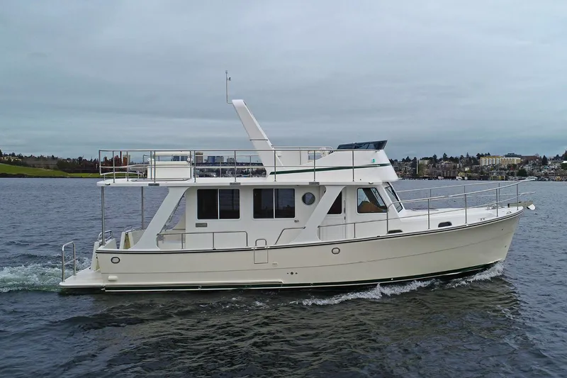 Slide: The Image of 2026 Helmsman Trawlers 38 Sedan cruising on a calm lake under overcast skies. - 2